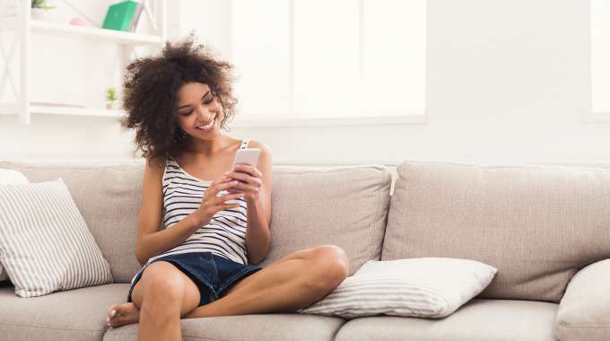Person relaxing on couch searching for easy ways to improve their personal finances