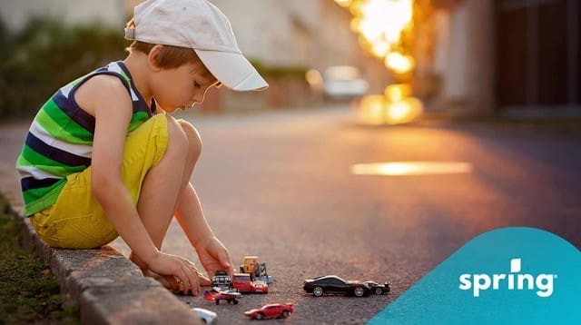 Child playing with toy cars in safe city in Canada