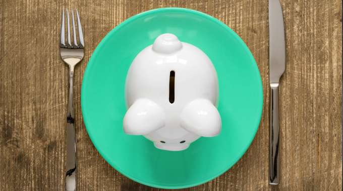 Piggy bank on a lunch plate signifies eating lunch on a budget