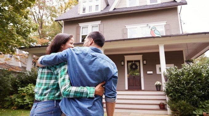 Happy Canadian Couple Standing in front of their first home